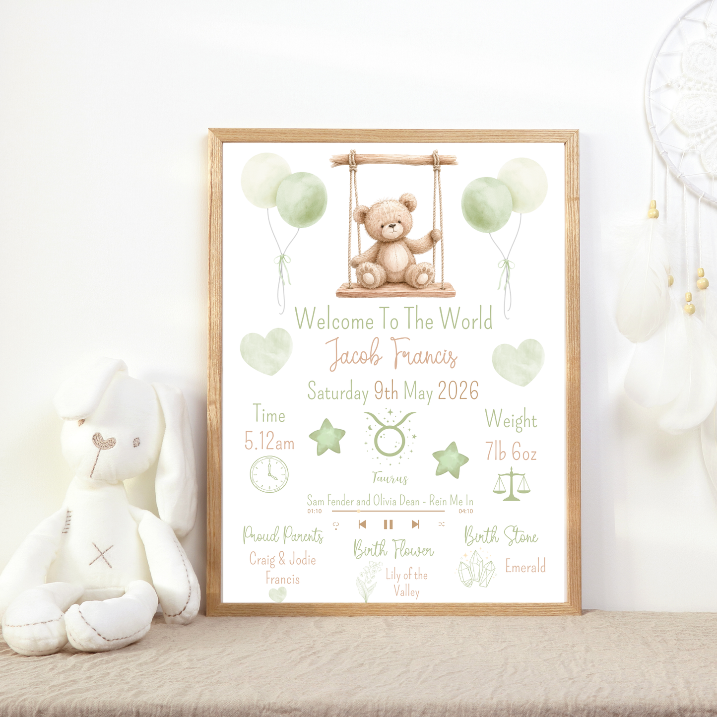 Framed birth announcement poster with teddy bear and balloons on a shelf with toys.