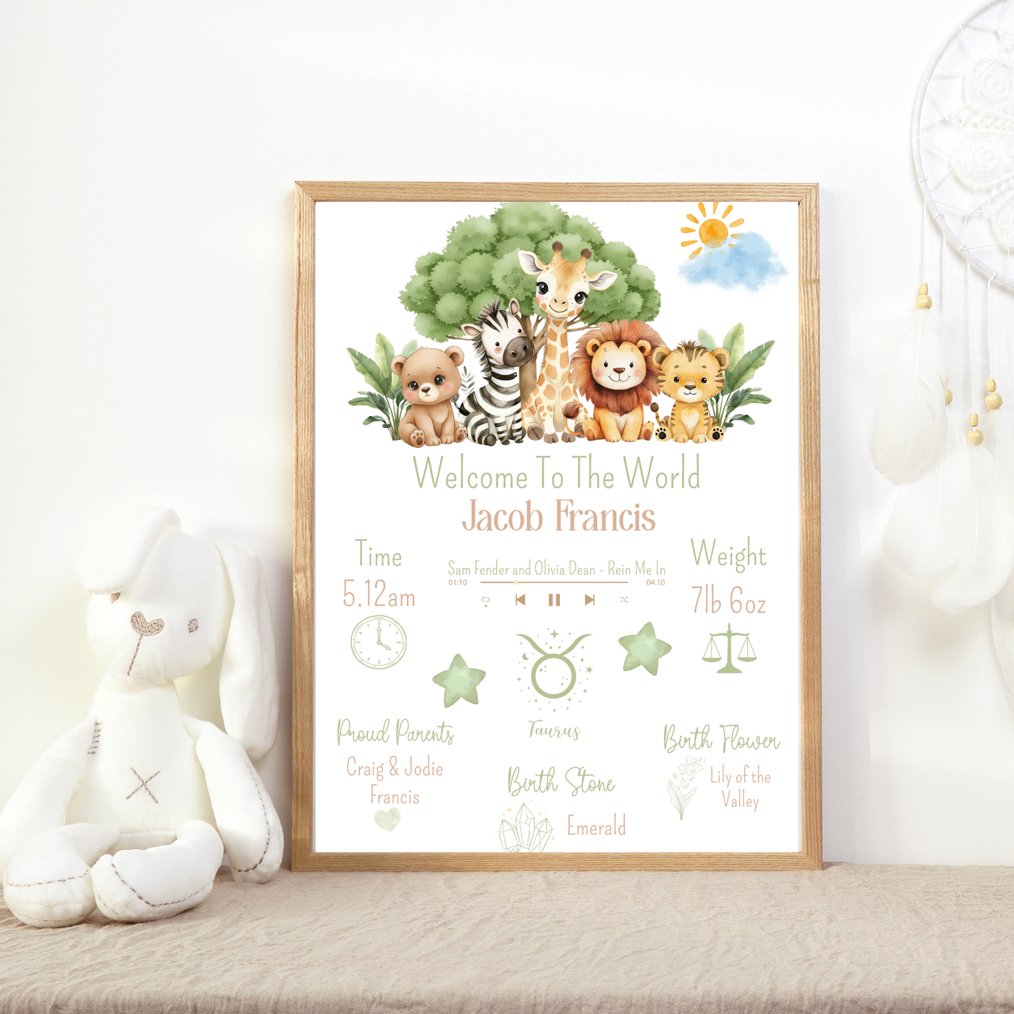 Framed baby announcement poster with cartoon animals on a white surface.