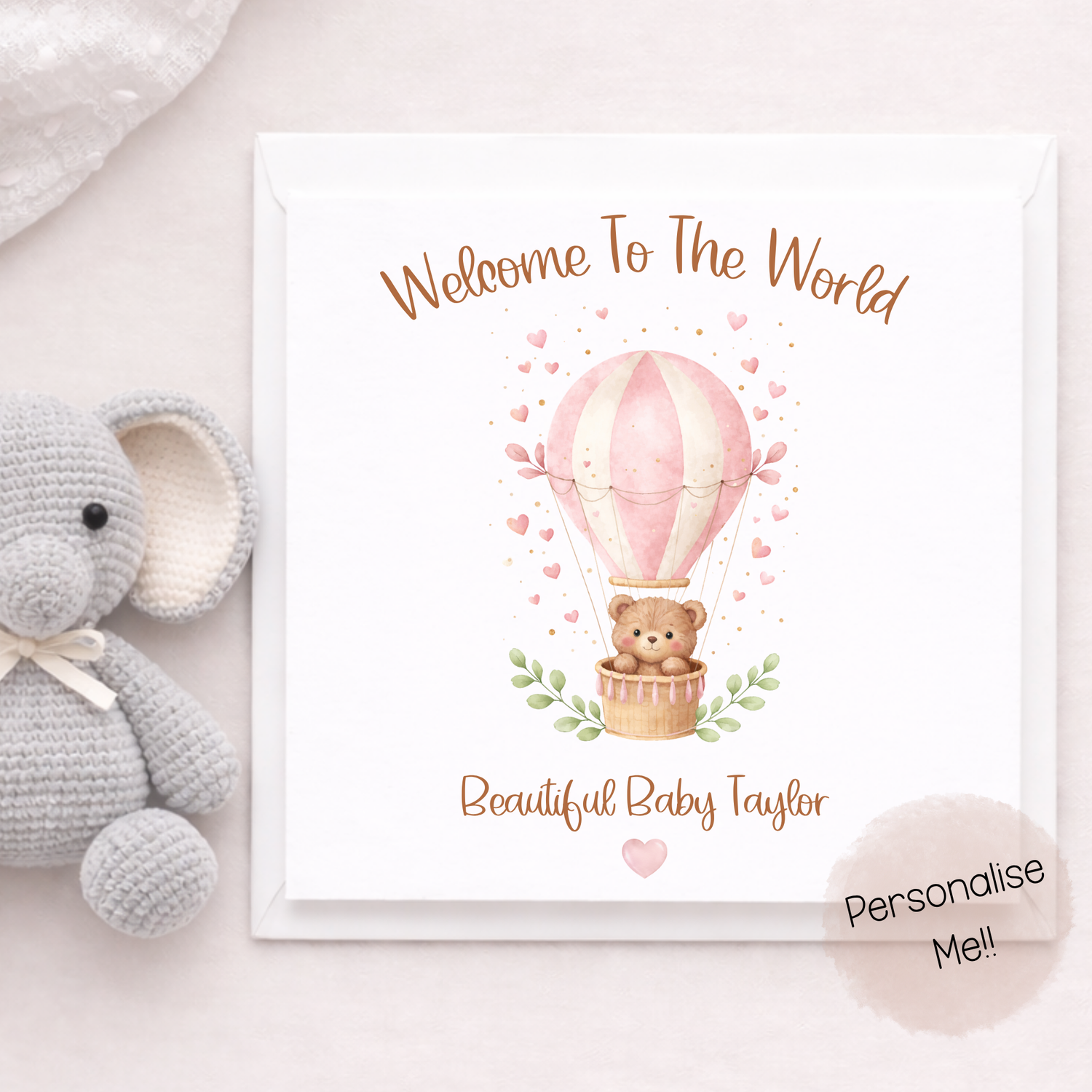 Baby shower card with teddy bear and hot air balloon illustration, accompanied by a plush elephant toy.