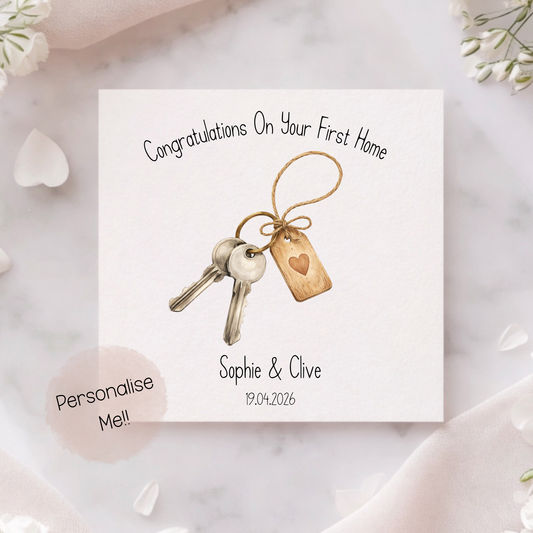 Greeting card with keys and a heart-shaped tag on a marble surface with flowers.