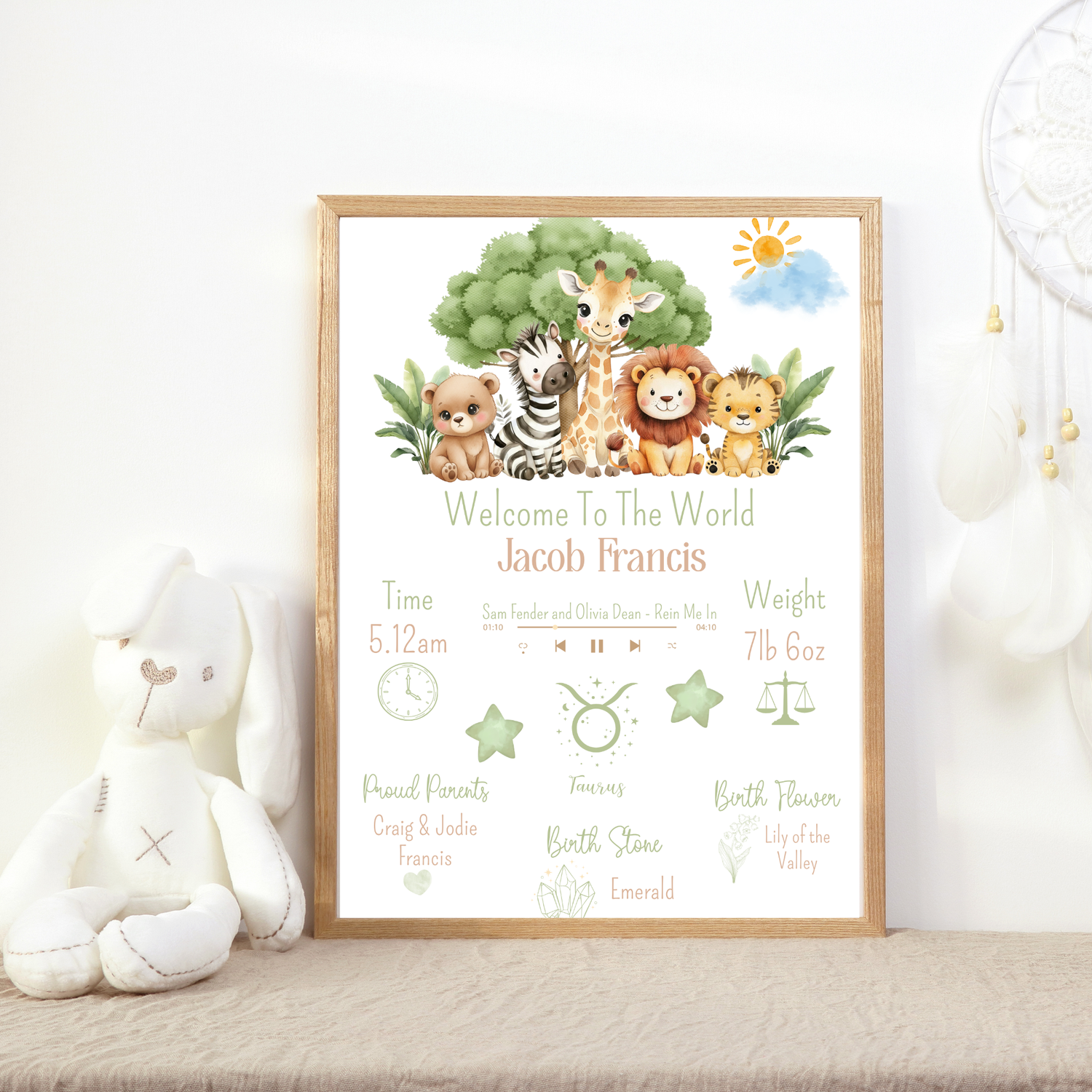 Framed baby announcement poster with cartoon animals on a white surface.