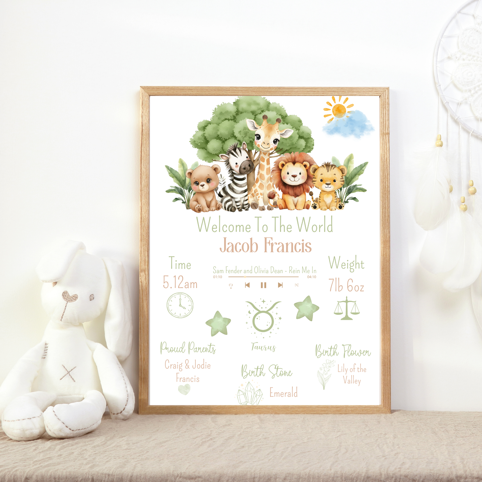 Framed baby announcement poster with cartoon animals on a white surface.