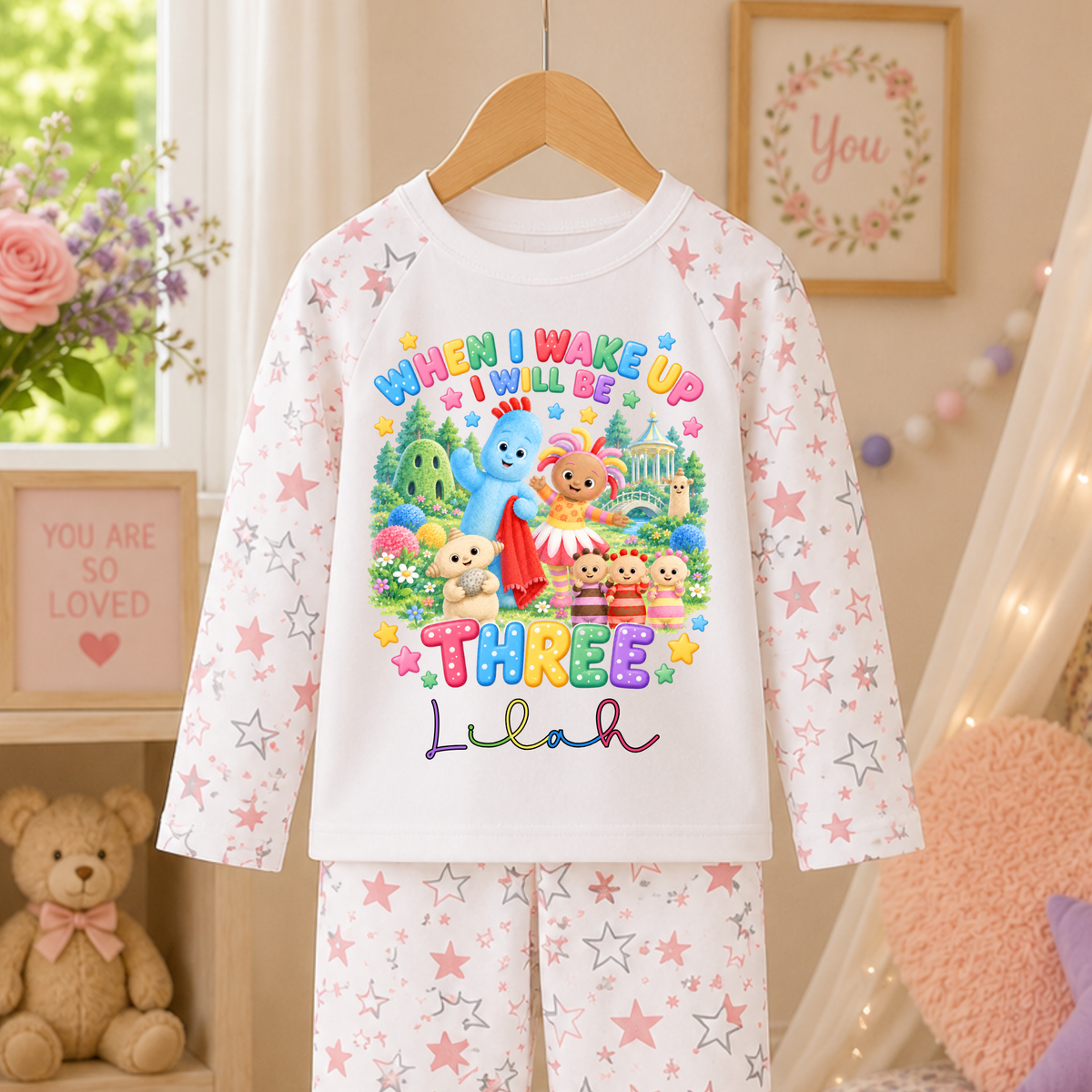 Personalised In the Night Garden birthday pyjamas with custom name and age, colourful character design and pink and white star-patterned sleeves and trousers.