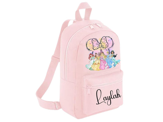 A light pink mini backpack with a front zippered pocket featuring the name 'Laylah' in black script. The main body has a colorful graphic of Disney princesses under a large bow.